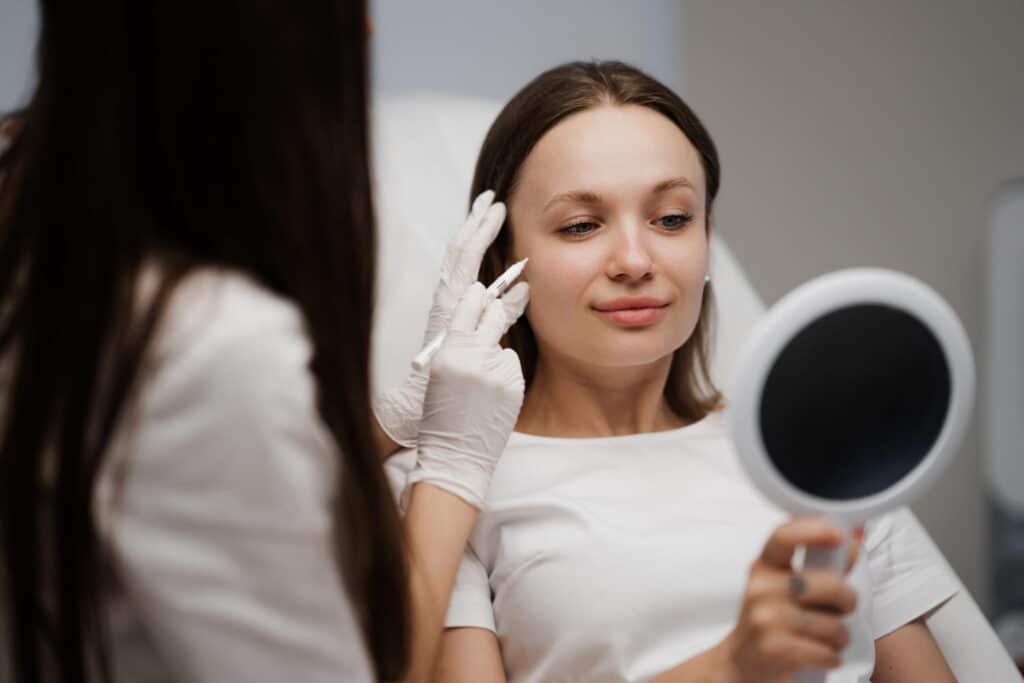 cosmetologist deciding on treatment for patient
